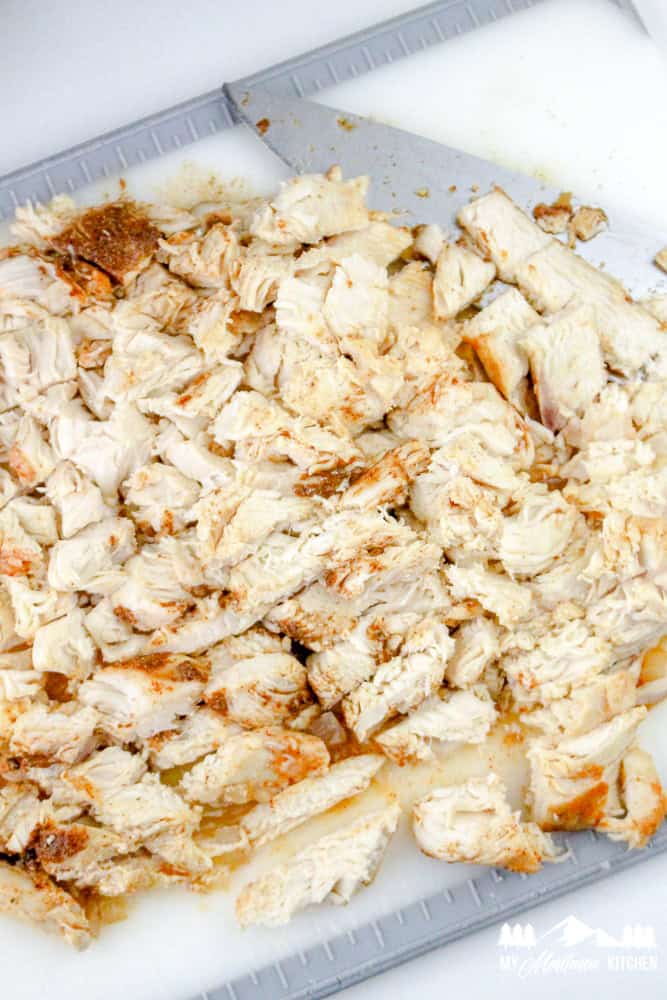 Diced cooked chicken breast seasoned and ready for enchilada casserole.