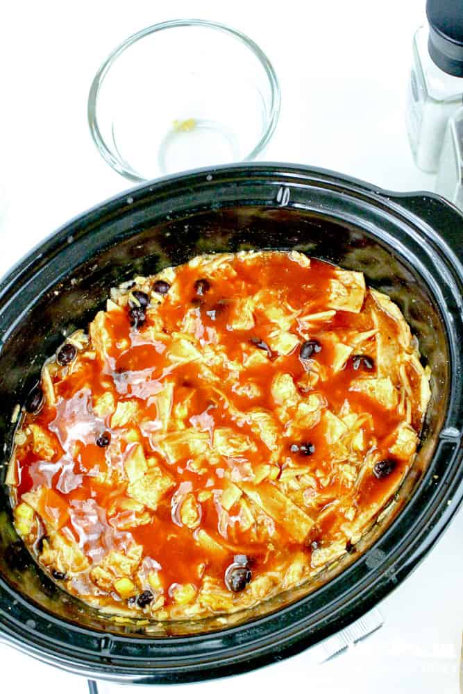 Slow cooked enchilada casserole with enchilada sauce and black beans in a crockpot.