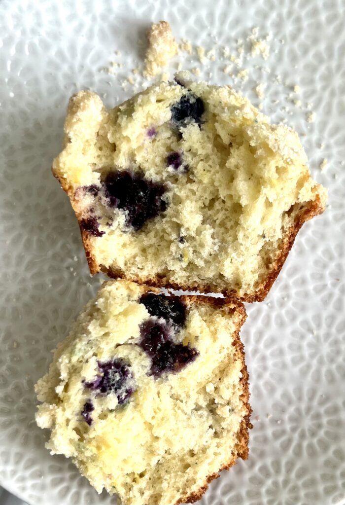 sourdough blueberry muffin broken apart on white plate