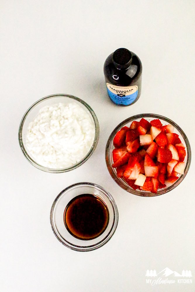 Ingredients laid out on counter—cottage cheese, strawberries, vanilla, syrup