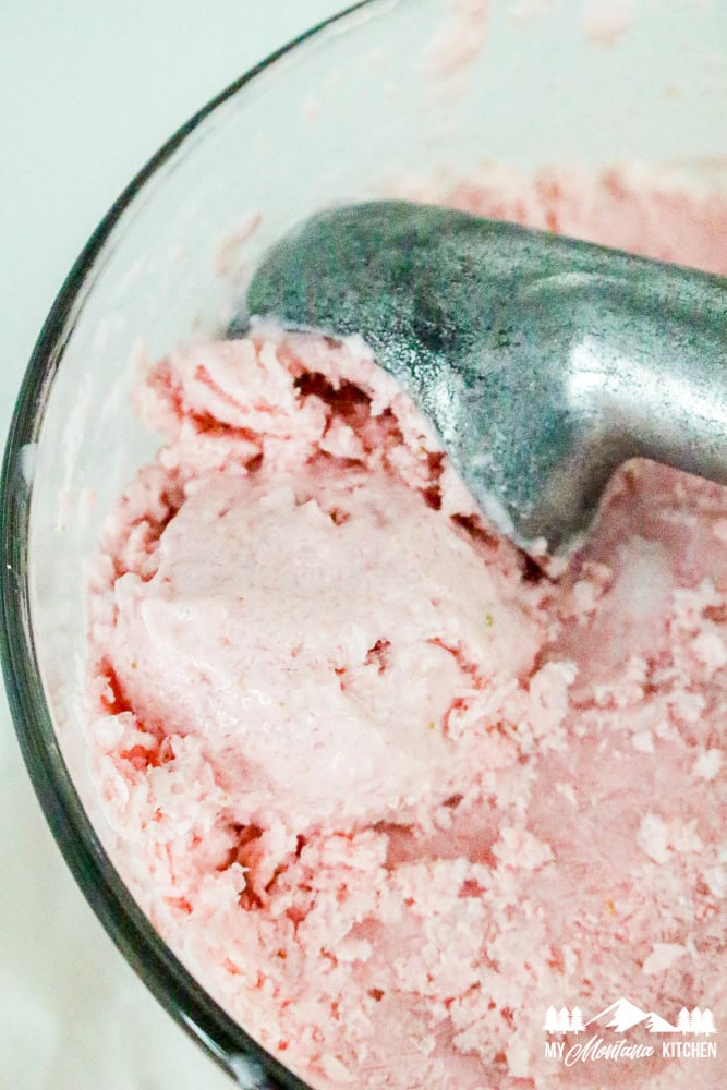 Scooping frozen strawberry cottage cheese ice cream