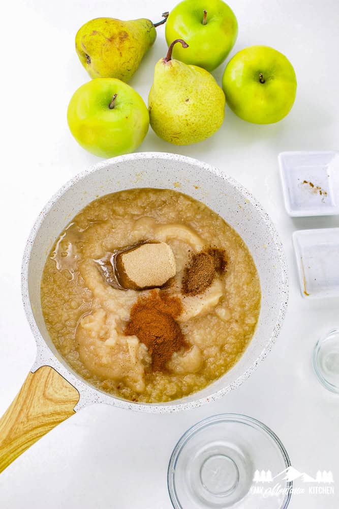 Pot of blended apple and pear sauce with cinnamon, nutmeg, and brown sweetener sprinkled on top.
