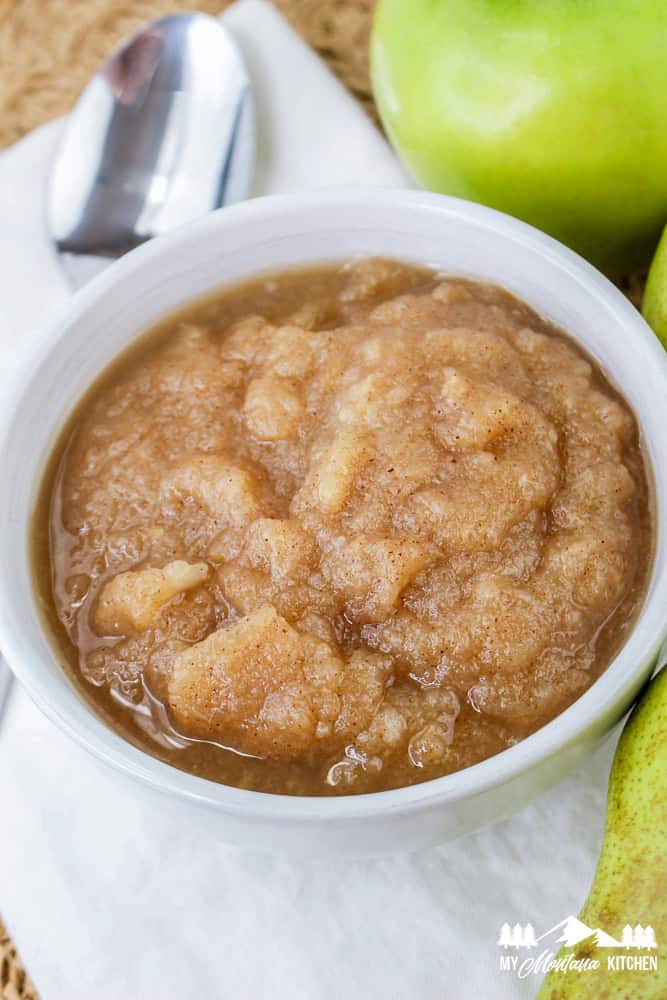 Close-up of chunky apple pear sauce in a white bowl with a rich cinnamon color.