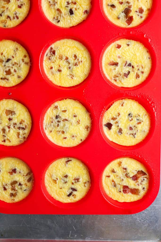 Close-up of baked cottage cheese egg bites with bacon in silicone muffin tin.