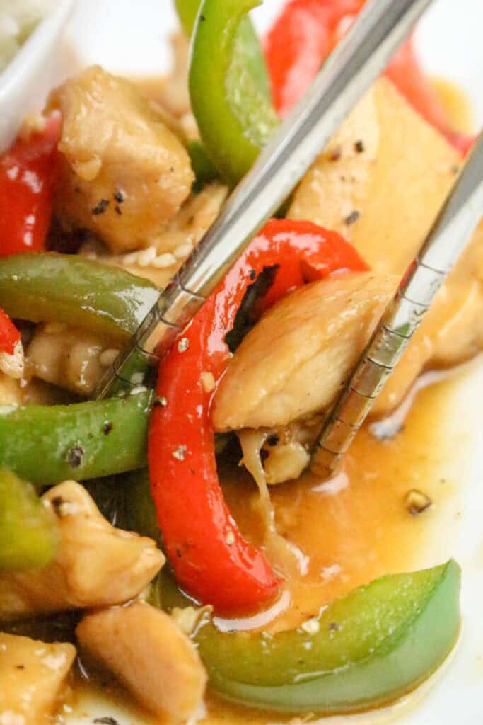 Close up of crispy honey pepper chicken pieces coated in a sticky honey glaze.